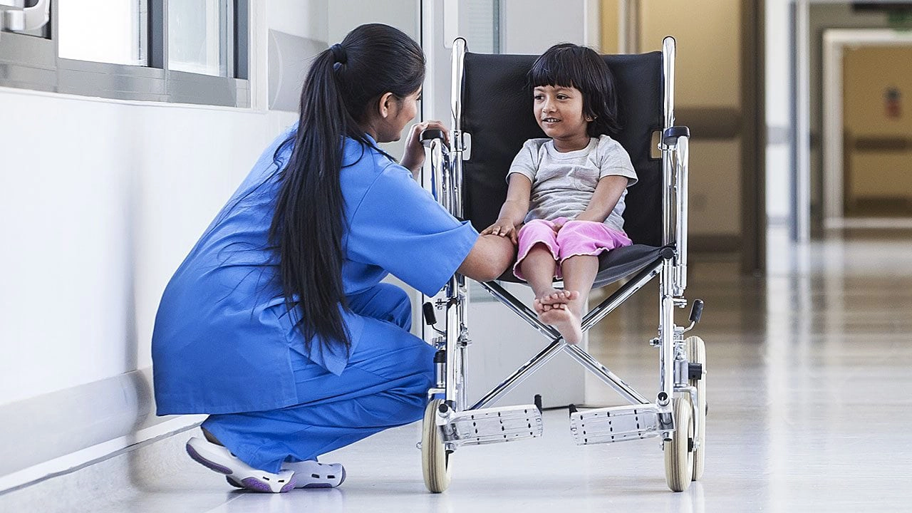 Nurse helping a child in a wheelchair - Asimily||Asimily Risk Remediation Platform - Accelerating Vulnerability Management IoMT