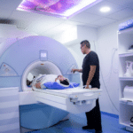 Stock photo of a patient in an MRI machine with a technician pressing buttons.