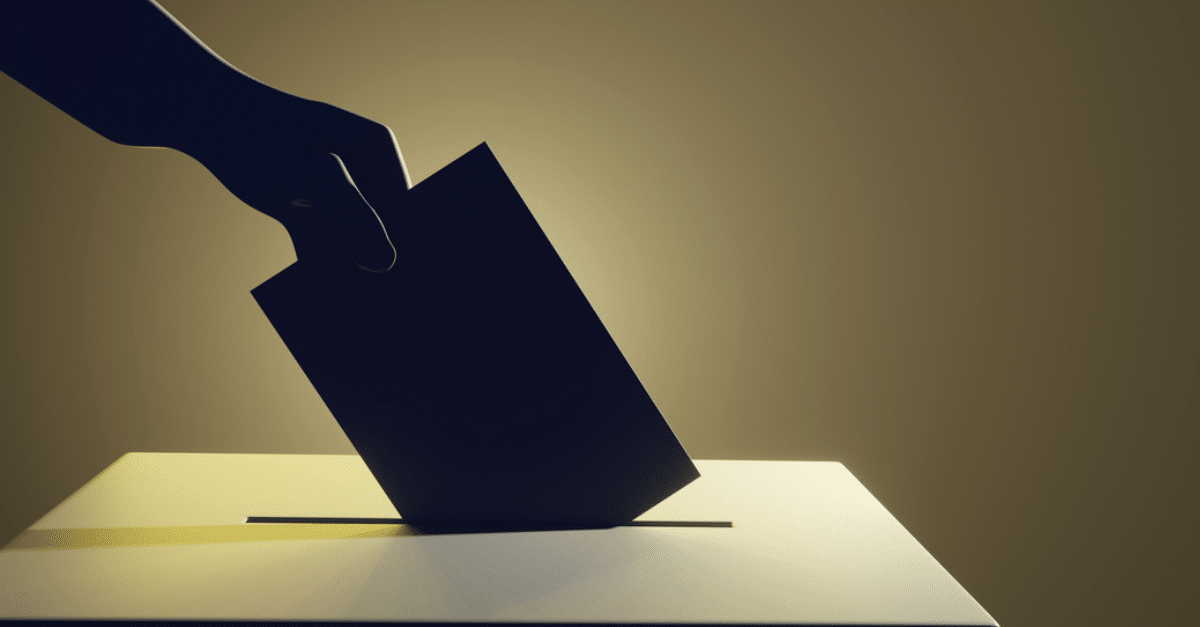 Stock photo of a person depositing a ballot in a ballot box.